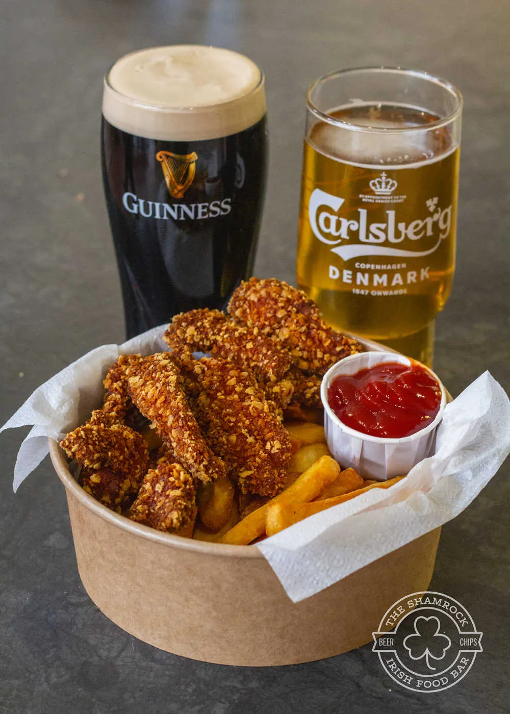 Basket of wings with a pint of Guinness on the bar