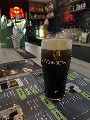 Pint of Guinness on the bar at the Classic, drinks menu underneath