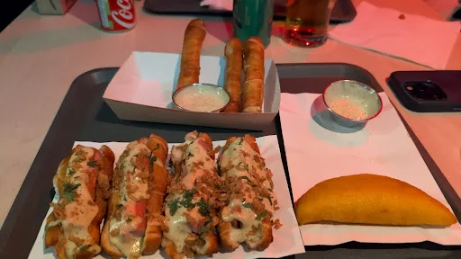 Loaded hot dogs and tequeños with dipping sauces